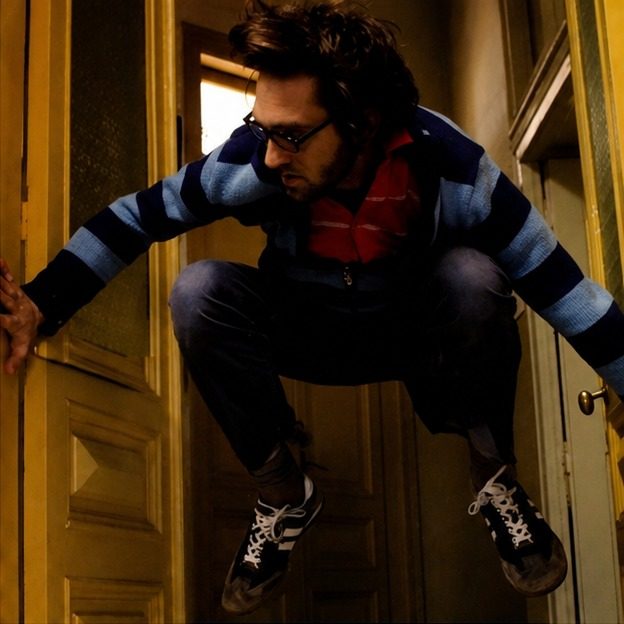 Editorial portrait of Tamir Hitman braced between two door frames